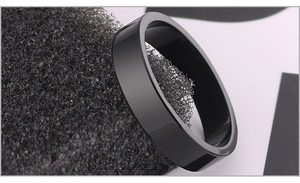 Macro view of polished black stainless steel flat ring on a textured black display base