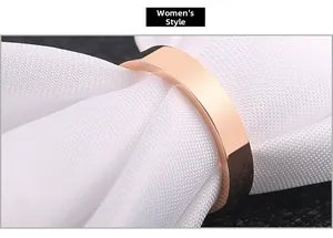 Detailed macro view of a polished rose gold stainless steel band ring on soft fabric