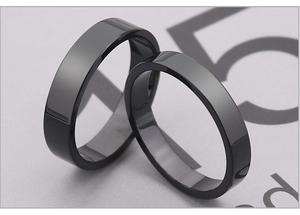 Macro shot of minimalist black polished titanium steel flat rings in wide and narrow widths