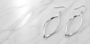 Détail de la finition poli miroir à 360 degrés sur les boucles d'oreilles torsadées