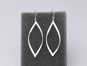 Détail macro de boucles d'oreilles pendantes géométriques sur support noir