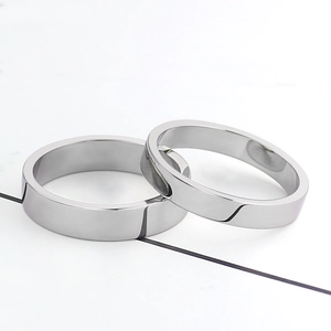 Polished titanium steel flat rings with geometric beveled edges on white background