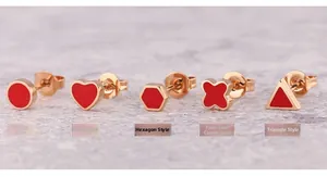 Macro shot of rose gold titanium earrings with red enamel in five geometric shapes