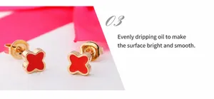 Detail view of red clover stud earrings with gold finish and dripping oil craftsmanship