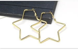 Makroaufnahme minimalistischer goldener Creolen in Sternform mit dünnem Drahtdesign