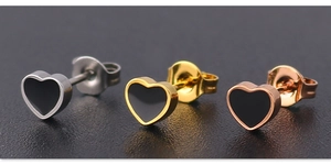 Macro shot of minimalist steel heart earrings in silver, gold, and rose gold finishes