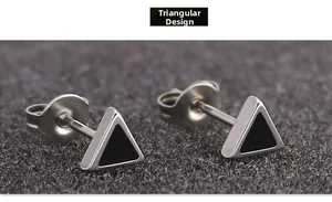 Macro shot of minimalist silver stainless steel triangle stud earrings with black enamel inlay