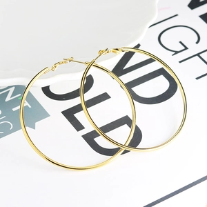 Minimalistische goldene Creolen in Übergröße mit geometrischem Design auf Weiß