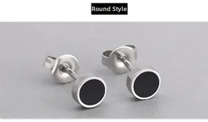 Close-up of minimalist round titanium steel stud earrings with black enamel inlay detail