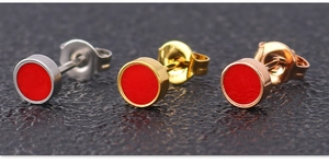 Close-up of red enamel round stud earrings in silver, gold, and rose gold finishes