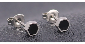 Macro detail of hexagonal silver stud earrings with black enamel inlay and butterfly backs