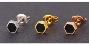 Detail of hexagonal geometric stud earrings in silver, gold, and rose gold with black enamel