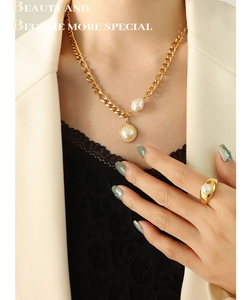 Detailed view of layered 18k gold plated chains with baroque pearl pendant on model