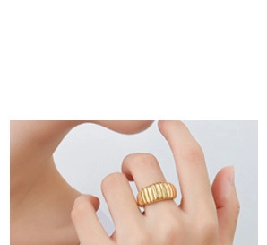 Détail d'une bague croissant dorée avec texture vintage nervurée portée à l'index