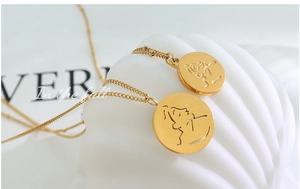 Vue macro de pendentifs portrait abstraits sur des colliers en acier inoxydable plaqué or