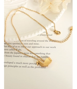 Détail du pendentif grue en origami plaqué or 18 carats sur une chaîne en acier titane