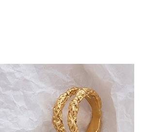 Detail eines breiten Goldrings mit unregelmäßiger Hammerschlagstruktur und Doppelband