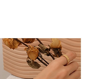 Detailansicht eines geflochtenen Goldrings mit Kordelstruktur auf einem Vintage-Hintergrund