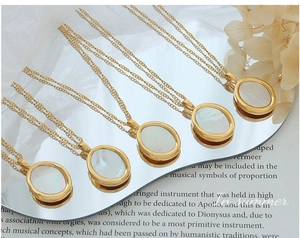 Vue détaillée de pendentifs ovales dorés en nacre disposés sur un miroir