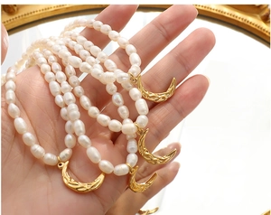 Detailed close-up of natural freshwater pearl necklace with gold crescent moon pendant