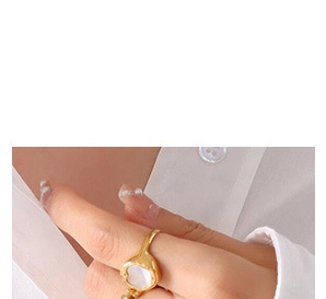 Detailed close-up of a heart-shaped pearl inlay on a minimalist gold-plated titanium ring