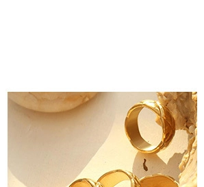Macro shot of gold-plated quilted rings featuring minimalist French luxury design