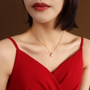 Minimalistische 18K vergoldete Titan-Halskette mit Zirkonia-Anhänger am Model präsentiert