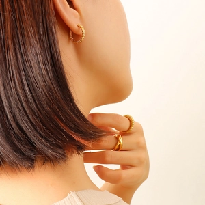 Boucles d'oreilles créoles texturées en or 18 carats et ensemble de bagues sur mannequin