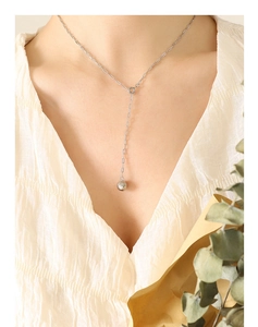 Macro shot of silver Y-shaped tassel necklace with geometric polygon ball pendant