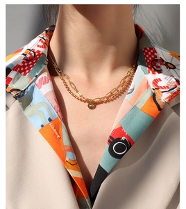 Gros plan du collier double épaisseur doré avec gravure Lucky sur pendentif rond