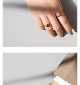 Détail d'une bague chaîne dorée avec lettre B évidée portée sur la main d'un mannequin