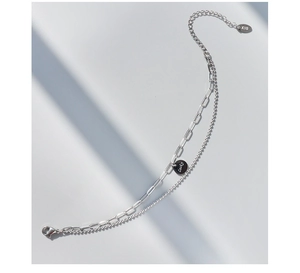 Détail d'un bracelet double couche argenté avec pendentif Lucky et logo K18 gravé