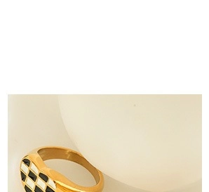 Primer plano del anillo de corazón dorado con diseño de esmalte de cuadros blancos y negros