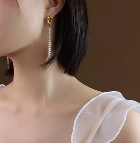 Orecchini pendenti in oro 18k con nappe in zirconia indossati da una modella reale