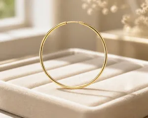 Detailed close-up of large polished gold hoop earrings with secure plug-in clasps