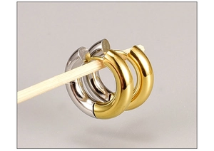Macro detail of polished gold and silver titanium steel hoop earrings on a display