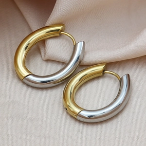 Polished two-tone gold and silver stainless steel oval huggie hoop earrings for women