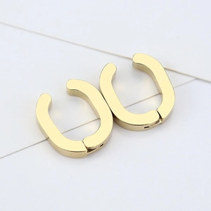 Detailed view of minimalist gold U-shape geometric ear clips with polished finish