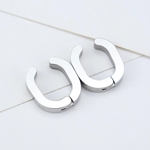 Detailed view of silver U-shaped clip-on earrings with polished geometric metal surface