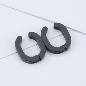 Detailed macro view of black geometric U-shaped clip earrings with matte titanium finish
