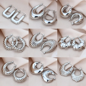 Lot de 9 paires de boucles d'oreilles créoles en acier argenté sur fond en soie rose