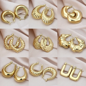 Collection de neuf boucles d'oreilles en acier titane doré aux styles géométriques