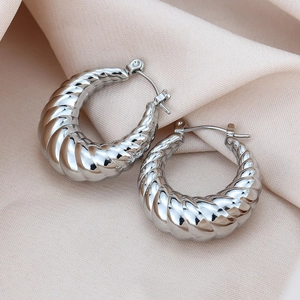 Détail de créoles en acier titane argenté avec un motif de corde en spirale texturé