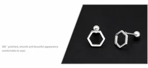 Close-up of hexagonal hollow earrings featuring mirrored finish and screw-back closure