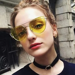 Schicke Cat-Eye-Sonnenbrille mit gelben Gläsern und Goldrahmen getragen von einem Model