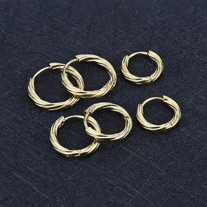 Macro-opname van drie paar gouden titanium stalen oorringen met gedraaid textuurdetail