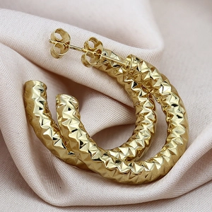 Modieuze gouden C-vormige holle creolen met een getextureerd diamantgeslepen patroon