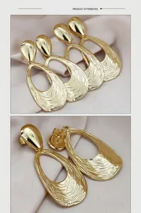 Macro detail of gold hammered metal drop earrings with hollow water-drop texture