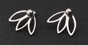 Détail macro de boucles d'oreilles argentées géométriques avec billes et pendentifs en feuille
