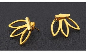 Détails des boucles d'oreilles dorées avec pétales découpés sur fond noir texturé